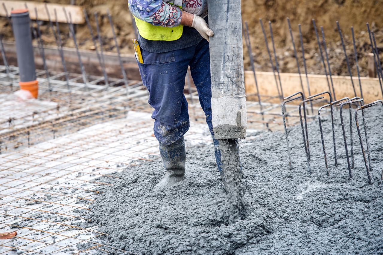 Crew pouring concrete over rebar for a slab foundation