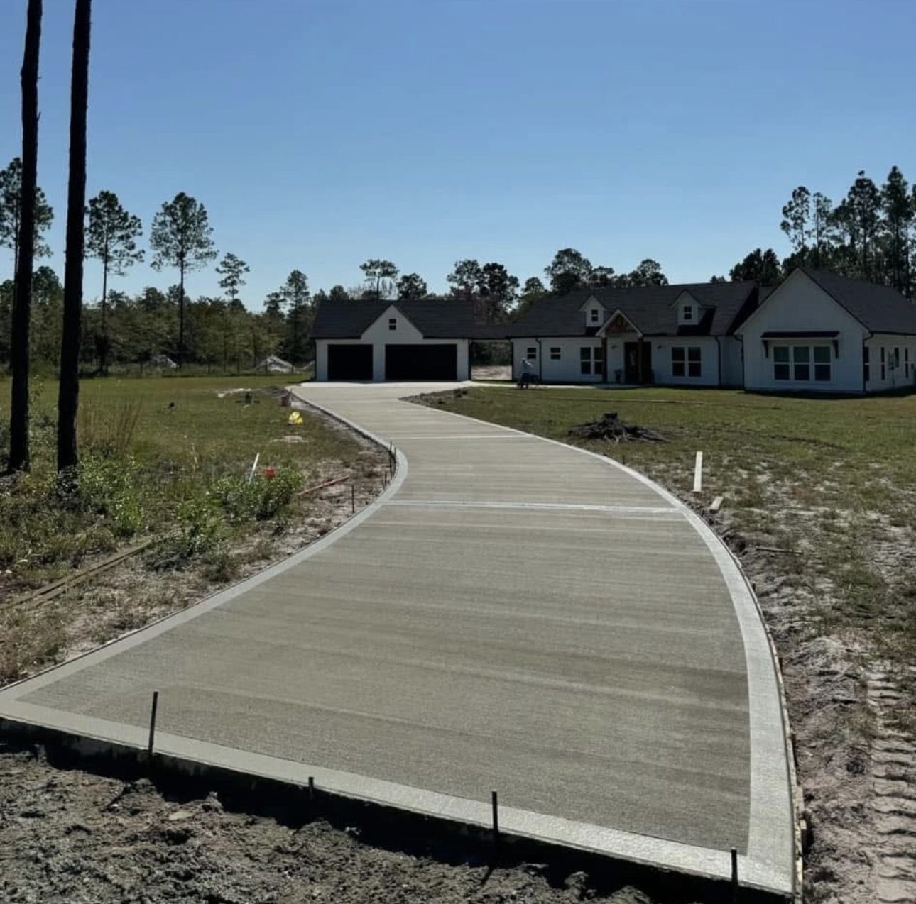 Curved broom-finish concrete driveway at a new construction home